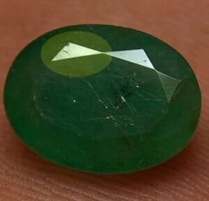 Emerald Treatment - Area highlighted in yellow shows the reflective light look & the dark lines which proves this emerald has fractures reaching the surface.